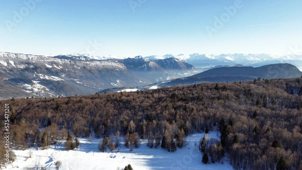 Obraz Panoramic view of snowy mountains in winter. Foggy mountains. Woods in front of the mountains.