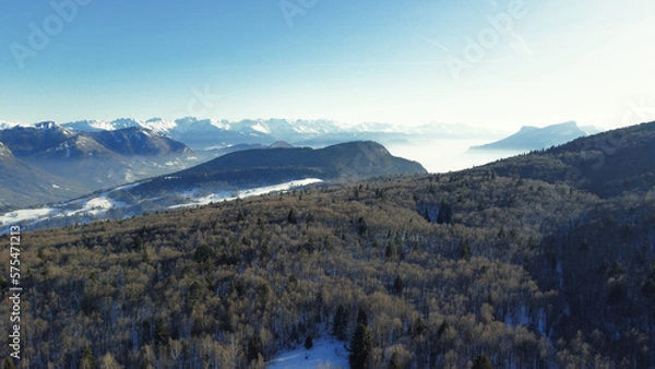 Obraz Panoramic view of snowy mountains in winter. Foggy mountains. Woods in front of the mountains.