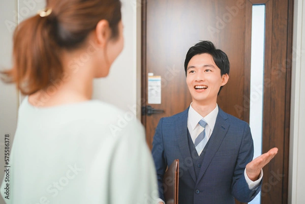 Obraz 訪問販売をする若いビジネスマンと主婦