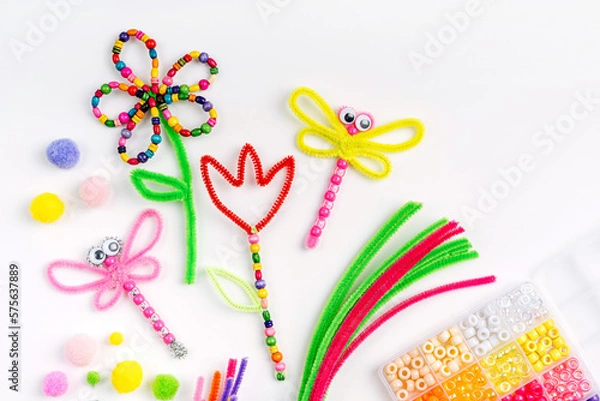 Fototapeta Beaded Pipe Cleaner flowers and dragonflies. Easy spring kids crafts. Different multi-colored supplies and materials for DIY art activity for kids. Children's crafts, creativity and  hobby.