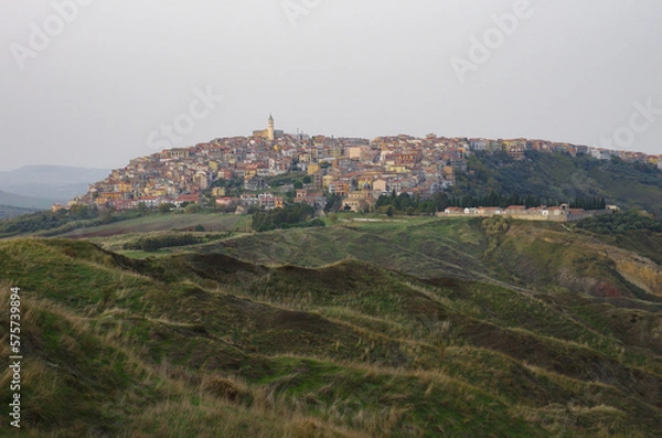 Fototapeta The landslide system with the gullies and in the background Montenero di Bisaccia, a small town in the lower Molise region, Italy