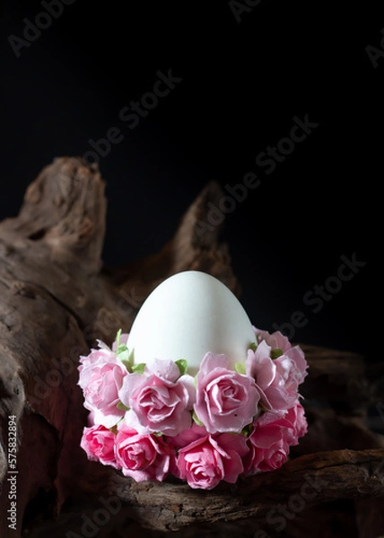 Fototapeta Easter egg with pink flowers on a rustic wood background.