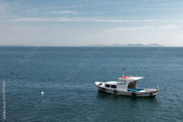 Fototapeta A small boat is anchored in the sea.