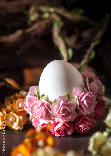 Fototapeta Easter egg decorated with pink flowers on a wooden background. Selective focus