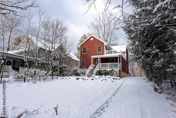 Fototapeta red suburban house with front yard and driveway covered with snow after snow storm