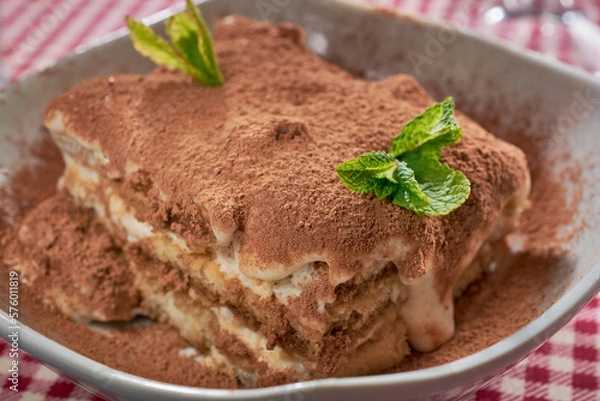 Fototapeta Tiramisu cake with fresh mint, close-up in a deep plate