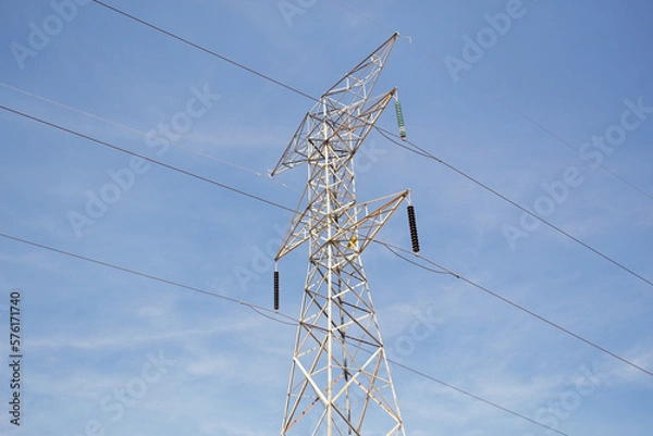 Fototapeta Metal electrical tower, with blue sky in the background. Electric tower side view.