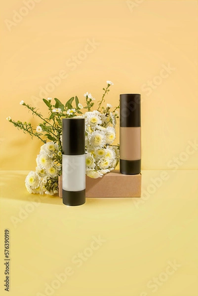 Fototapeta Prebase y base de maquillaje, con fondo color amarillo y flores. Ideal para una marca de cosmética natural