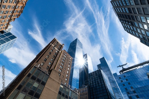 Fototapeta NEW YORK, NEW YORK – AUGUST 11: The sun illuminates the Vessel and newly built high-rise buildings in Hudson Yards at Midtown Manhattan on August 11, 2022 in New York City.