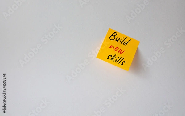 Fototapeta Build New skills symbol. Concept word Build New skills on orange steaky note. Beautiful white background. Business and Build New skills concept. Copy space