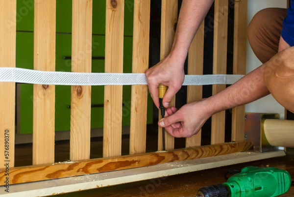 Fototapeta Work with a screwdriver when spinning a screw in the wood