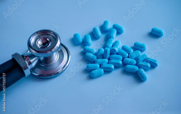 Fototapeta A pile of scattered pills with a stethoscope. Medical background. Medical first aid kit and medicine concept.
