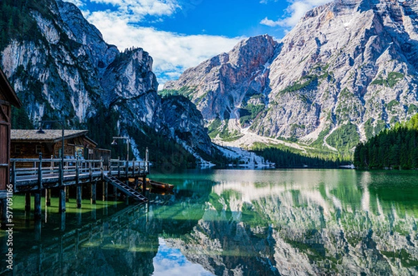 Fototapeta Lake surrounded by the mountains of the Italian alps. Fabulous views, magnificent mountains and lake. Free space for inscription text poster on backdrop nature Lake Braies emerald clear water.