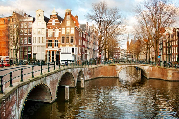 Obraz Old bridges and traditional houses along a canal in the centre of Amsterdam, the Nederlands