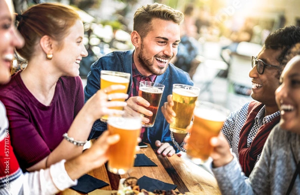 Fototapeta Young people drinking beer pints at brewery bar garden - Genuine beverage life style concept with guys and girls sharing happy hour together at open air pub dehor - Warm sunset backlight filter