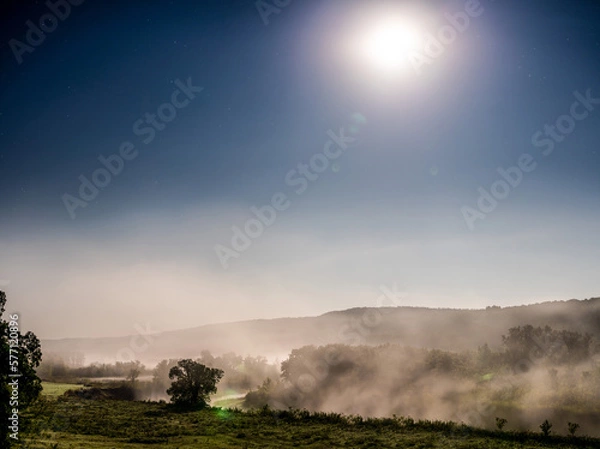 Fototapeta Moon light shinning through the fog covered valley