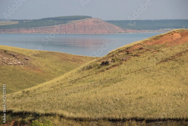 Fototapeta rocky hills and ravine. red mountain on the other side of the lake