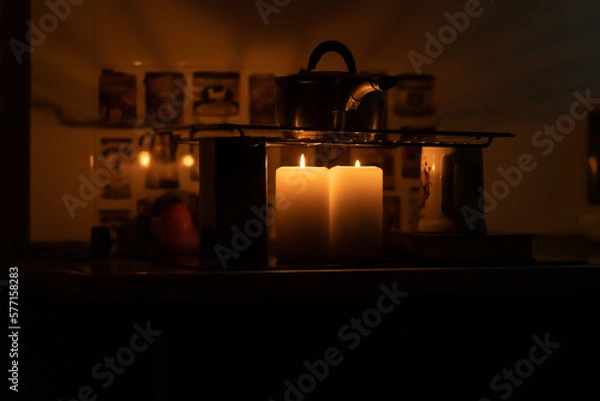 Fototapeta The pot stands on the grate and is heated by candles