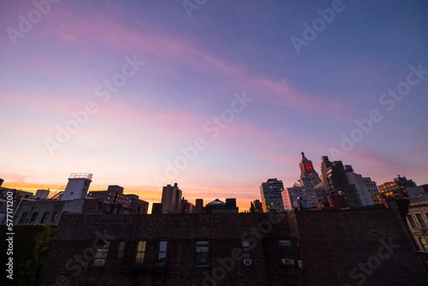 Fototapeta NEW YORK, NEW YORK USA – OCTOBER 22, 2022: Sky glows over the East Village cityscape during twilight in New York City.
