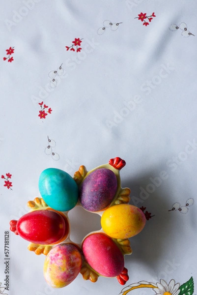 Obraz Top view of colored easter eggs on a white tablecloth