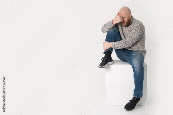 Fototapeta Bold bearded sad man is crying . Isolated. White background