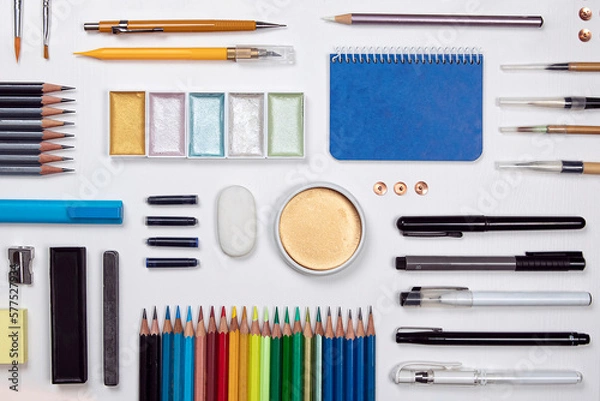 Fototapeta Stationery flat lay composition on white background. Creative designer, artist, equipment on white desk. Variety of office objects as paint, brush, pencil, marker pen and more view from above.