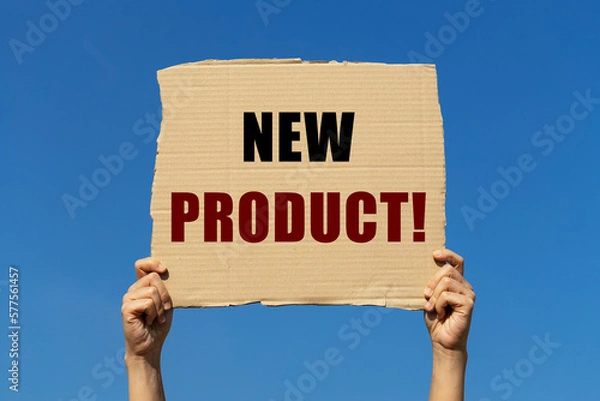 Fototapeta New product text on box paper held by 2 hands with isolated blue sky background. This message board can be used as business concept to inform audience about new product.