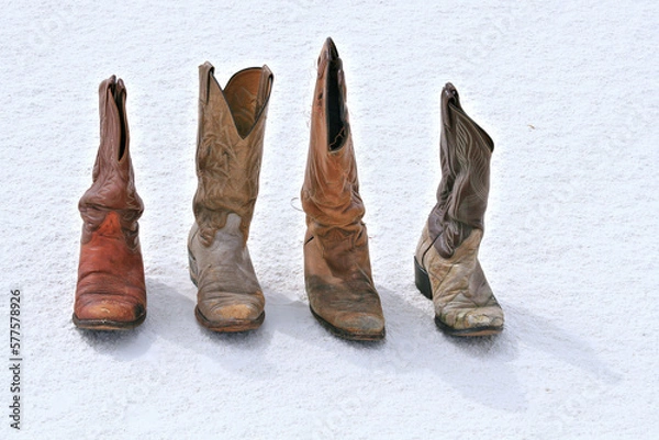 Obraz old worn cowboy boots on desert sand dune