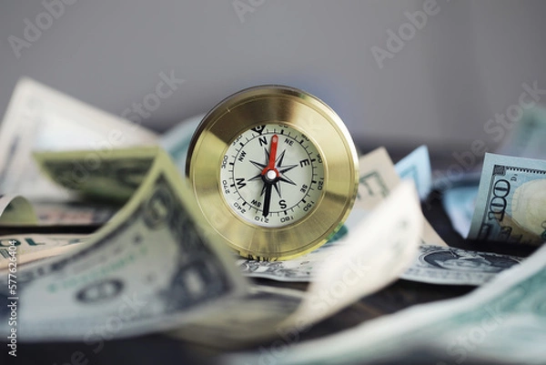 Fototapeta Money bill with golden Compass. Bullets and cartridge cases as a military concept. Close up US Currency and compass. business, financial idea, concept, symbol of crisis, inflation