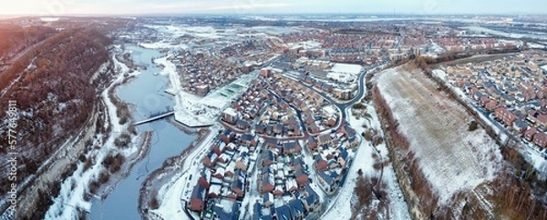Fototapeta Aerial drone. Ebbsfleet garden city in Kent, covered in snow in December 2022. Aerial view of new developments and frozen lake alongside the A2 motorway.