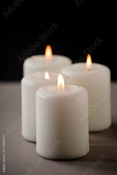 Fototapeta set of burning white candles on the shelf with black background