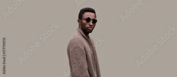 Obraz Portrait of stylish young african man model wearing knitted cardigan isolated on gray background