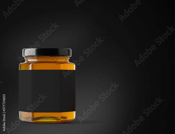 Fototapeta Jar of honey with label on a black background.