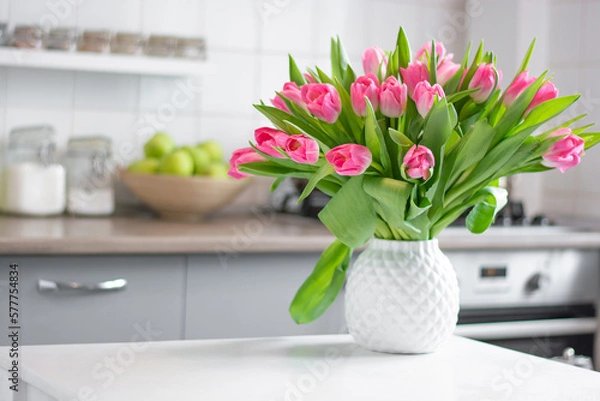 Fototapeta a bouquet of tulips in a white vase stand on the kitchen table. Kitchen background