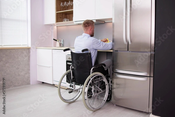 Fototapeta Man With Disability Sitting In Wheel Chair Preparing Food