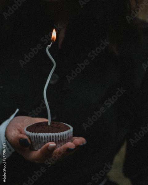 Obraz Hand holding a birthday cake with a candle
