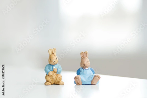 Fototapeta Handmade Easter bunny. Blurred background. Easter toys. Wooden Easter eggs on white background, copy space.