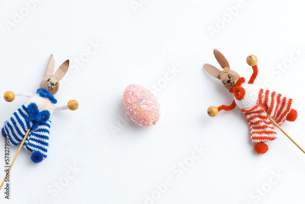 Fototapeta Easter toys. Wooden Easter eggs and rabbits on white background, copy space.