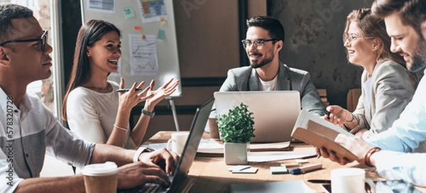 Obraz Happy business team working together while sitting at the desk in office
