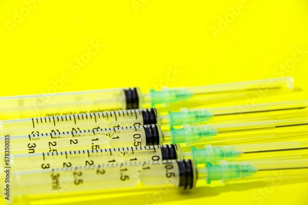 Obraz syringe and needle on yellow background