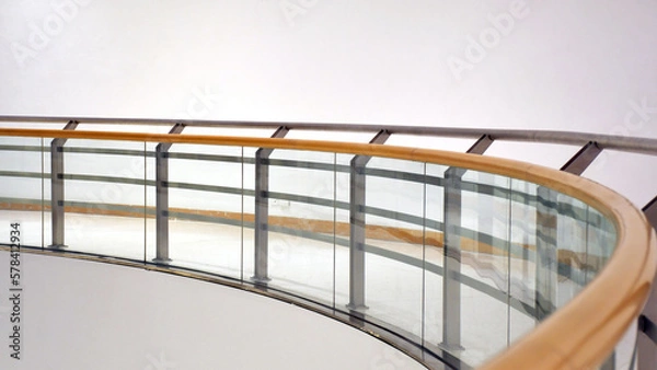 Fototapeta Wood hand rail curve balcony or terrace design with glazing profile. Tempered laminated glass railing balustrade panels frame less ,safety glass for modern architectural buildings.
