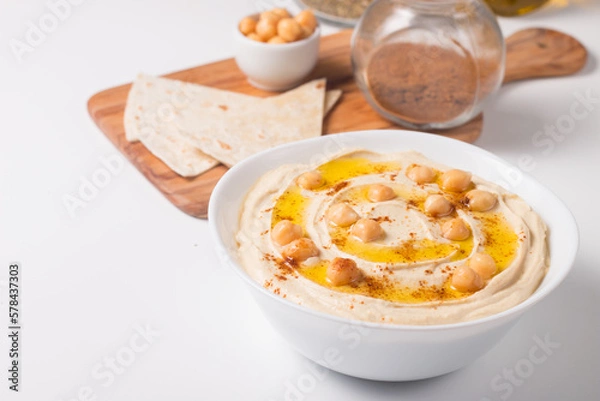 Obraz Hummus in a plate with chickpeas, smoked paprika, olive oil and pita. Vegetarian food.
