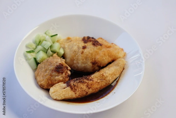 Fototapeta Pempek is a savoury Indonesian fishcake delicacy, made of fish and tapioca from Palembang. Pempek is served with sweet and sour sauce.