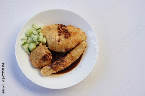 Fototapeta Pempek is a savoury Indonesian fishcake delicacy, made of fish and tapioca from Palembang. Pempek is served with sweet and sour sauce.