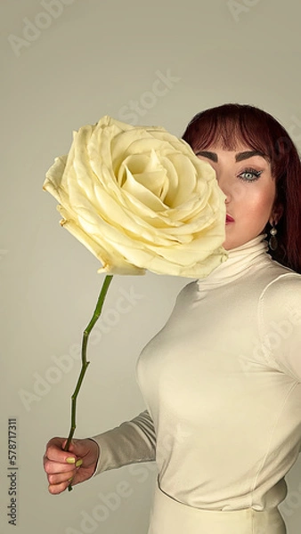 Fototapeta Mujer de ojos azules, posando con rosa amarilla. 