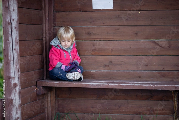 Obraz A little girl at a bus stop in a small idyllic village