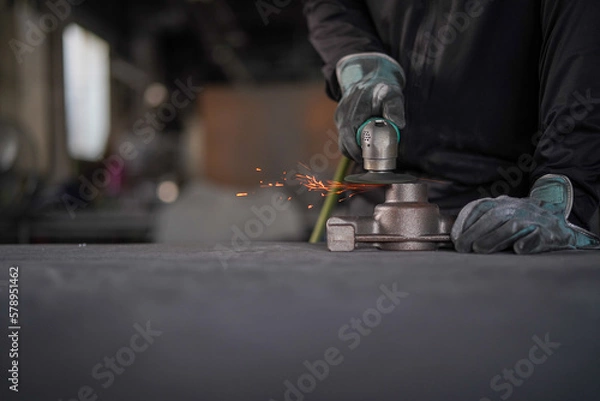 Obraz サンダーで部品加工をする手元