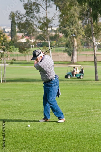 Fototapeta A golfer plays a round of golf at the country club resort
