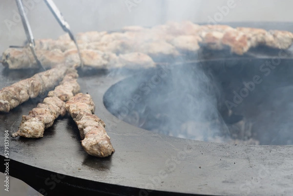 Fototapeta Grilling a chicken, summer picnic in backyard. Healthy and fastfood concept. Barbecue grill, fire, flame. Soft focus.