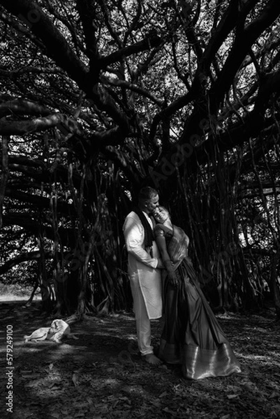 Fototapeta Wedding of a couple from Europe in India. A light skinned man in a traditional Indian men. white skin. Bride in beautiful sari with mehendi. Caucasian marriage. International couple.Lovely couple fit 